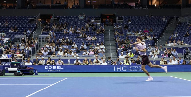 Hard-court tennis match under stadium lights, illustrating in-play betting at the US Open